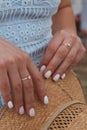 Vertical shot of a female with beautiful gold diamond rings on both hands holding a weaved hat Royalty Free Stock Photo