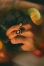 Vertical shot of a female hand with rings, bokeh lights, artsy aesthetic