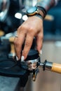 Vertical shot of a female hand suppressing and leveling the coffee powder