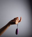 Vertical shot of the female holding the purple sex toy vibrator