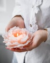 Vertical shot of a female holding a rose-shaped candle in a spa under the lights Royalty Free Stock Photo