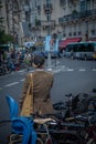 Vertical shot of a female in a jacket near a rack of bikes on a road in Paris, France