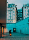 Vertical shot of a female standing with a bagage looking at the Grand Park hotel in Budapest