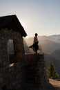 Vertical shot of a female standing on a building with a black skirt wavering in the wind