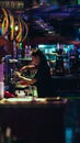 Vertical shot of a female worker in a bar with neon lights in Edinburgh, United Kingdom