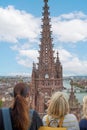 Vertical shot of females looking at the Basel Minister building during daytime in Basel, Switzerland