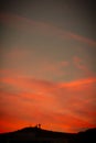 Vertical shot of fiery red sunset seen through a mountain silhouette - perfect for wallpapers
