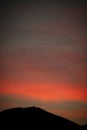 Vertical Shot Of Fiery Red Sunset Seen Through A Mountain Silhouette - Perfect For Wallpapers