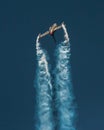 Vertical shot of a fighter jet blowing smoke for an airplane show