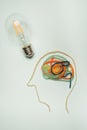 Vertical shot of a figure of a man's head with the light bulb on the side - invention concept Royalty Free Stock Photo