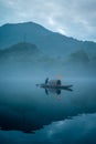 Vertical shot of a fisherman on a picturesque misty lake in Chenzhou,China Royalty Free Stock Photo