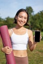 Vertical shot of fit and healthy young asian woman, shows smartphone screen with her workout stats, recommends telephone