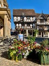 Vertical shot of flowers in a wooden box with traditional Tudor houses in the background