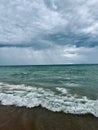 Vertical shot of fluffy clouds in the sky over the Lake Michigan with the storm in the horizon Royalty Free Stock Photo