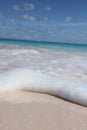 Vertical shot of foamy waves coming to the sandy Bermuda beach Royalty Free Stock Photo