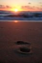Vertical shot of a footstep on the sand in the beach during the sunset Royalty Free Stock Photo