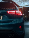 Vertical shot of a Ford MK4 car with water drops after the rain under the city lights