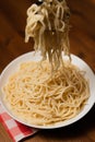 Vertical shot of a fork taking a portion of a tasty spaghetti