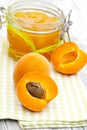 Vertical shot of fresh apricots and a jar of apricot jam on a napkin on a table Royalty Free Stock Photo