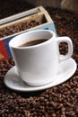 Vertical shot of fresh espresso cup on background of coffee beans Royalty Free Stock Photo