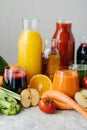 Vertical shot of fresh fruit and vegetable juice in glass bottles, different ingredients, white background. Healthy eating and Royalty Free Stock Photo