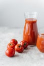 Vertical shot of fresh red tomato juice in glass, red fresh raw tomatoes near on white background. Making ketchup. Organic drink Royalty Free Stock Photo