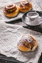 Vertical shot fresh sweet homemade cinnamon rolls with chocolate cream on a baking sheet. Scandinavian cuisine. Hyugge style