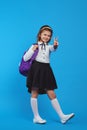 Vertical shot of full body girl wearing backpack and showing peace gesture Royalty Free Stock Photo