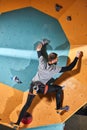 Full length view of unrecognizable active man with physical disability practicing bouldering hobby