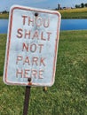 Vertical shot of a Funny no parking sign saying "thou shalt not park here"