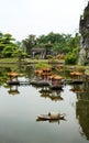 Vertical shot of a garden with a chinese style garden house on a lake and greenery in the background Royalty Free Stock Photo