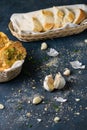 Vertical shot of garlic cloves and herbed bread on a gray table