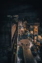 Vertical shot of Glasgow city center at night filled with lights and people passing the street