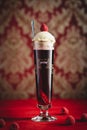 Vertical shot of a glass of Belgian lambic beer fermented using raspberries with ice cream.