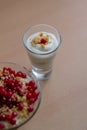 Vertical shot of a glass bowl of vanilla yogurt with currants on top on a beige background