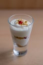 Vertical shot of a glass bowl of vanilla yogurt with currants on top on a beige background