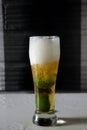 Vertical shot of a glass of cold beer with slices of lime Royalty Free Stock Photo