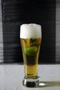 Vertical shot of a glass of cold beer with slices of lime Royalty Free Stock Photo