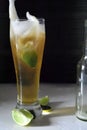 Vertical shot of a glass of cold beer with slices of lime on a white table Royalty Free Stock Photo