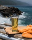 Vertical shot of a glass of cold beer on a wooden surface at a beach Royalty Free Stock Photo