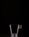 Vertical shot of a glass espresso cup isolated on a black background