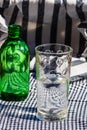 Vertical shot of a glass and a green bottle of water on a table Royalty Free Stock Photo