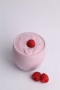 Vertical shot of a glass of liquid raspberry yogurt isolated on a gray background