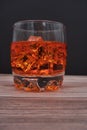 Vertical shot of a glass of whiskey with ice on a wooden table - perfect for drink concepts Royalty Free Stock Photo