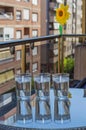 Vertical shot of glasses of ice water on a glass table on the balcony of the house Royalty Free Stock Photo