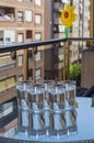 Vertical shot of glasses of ice water on a glass table on the balcony of the house Royalty Free Stock Photo