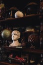 Vertical shot of a globe, an ivory head and other vintage stuff on a shelf.