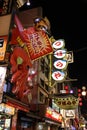 Vertical shot of glowing signs advertising food and restaurants in Dotonbori at night in Osaka,Japan