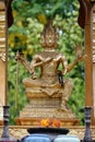 Vertical shot of a golden goddess statue in a spirit house in Chiang Mai, Thailand