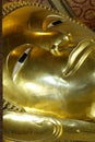 Vertical shot of the golden Reclining Buddha statue in the Wat Pho temple Royalty Free Stock Photo